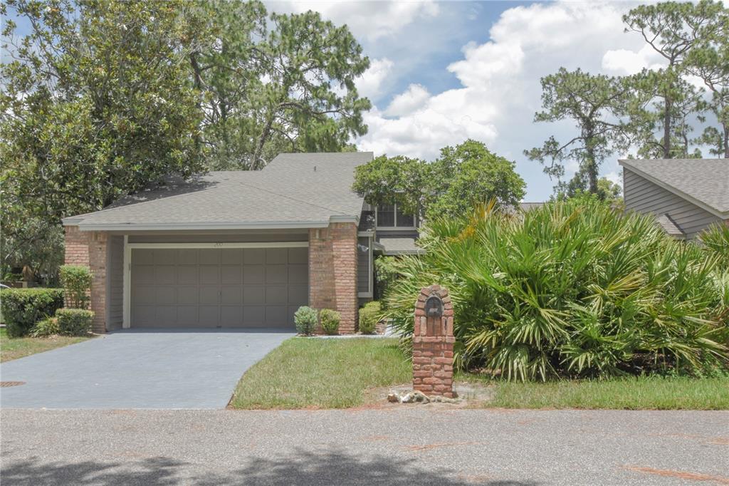 front view of a house with a yard and potted plants