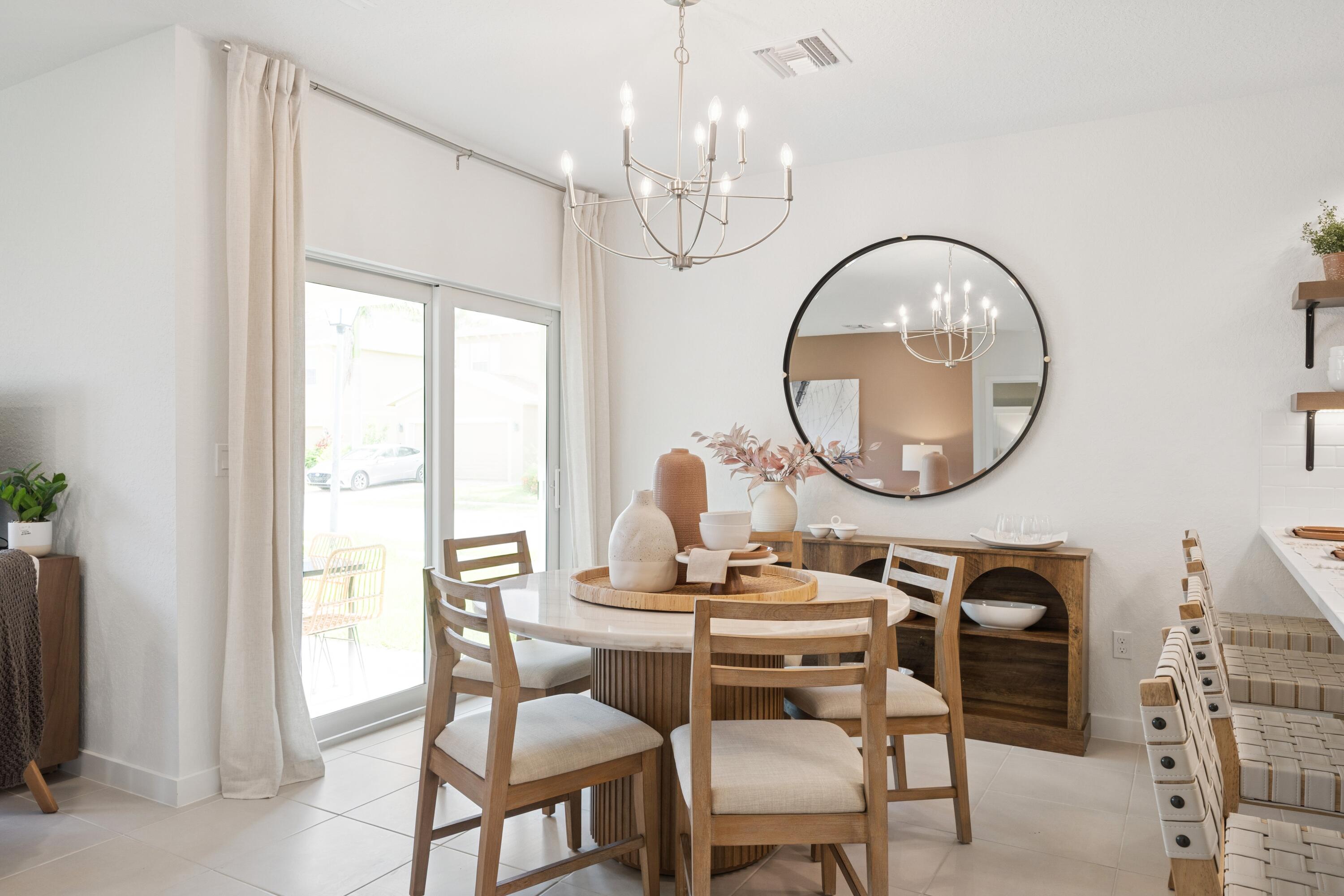 9744 Apollo Avenue, Unit 1 Fort Pierce, FL 34945 - Photo 24 of 39 a dining room with chandelier a mirror and a large window