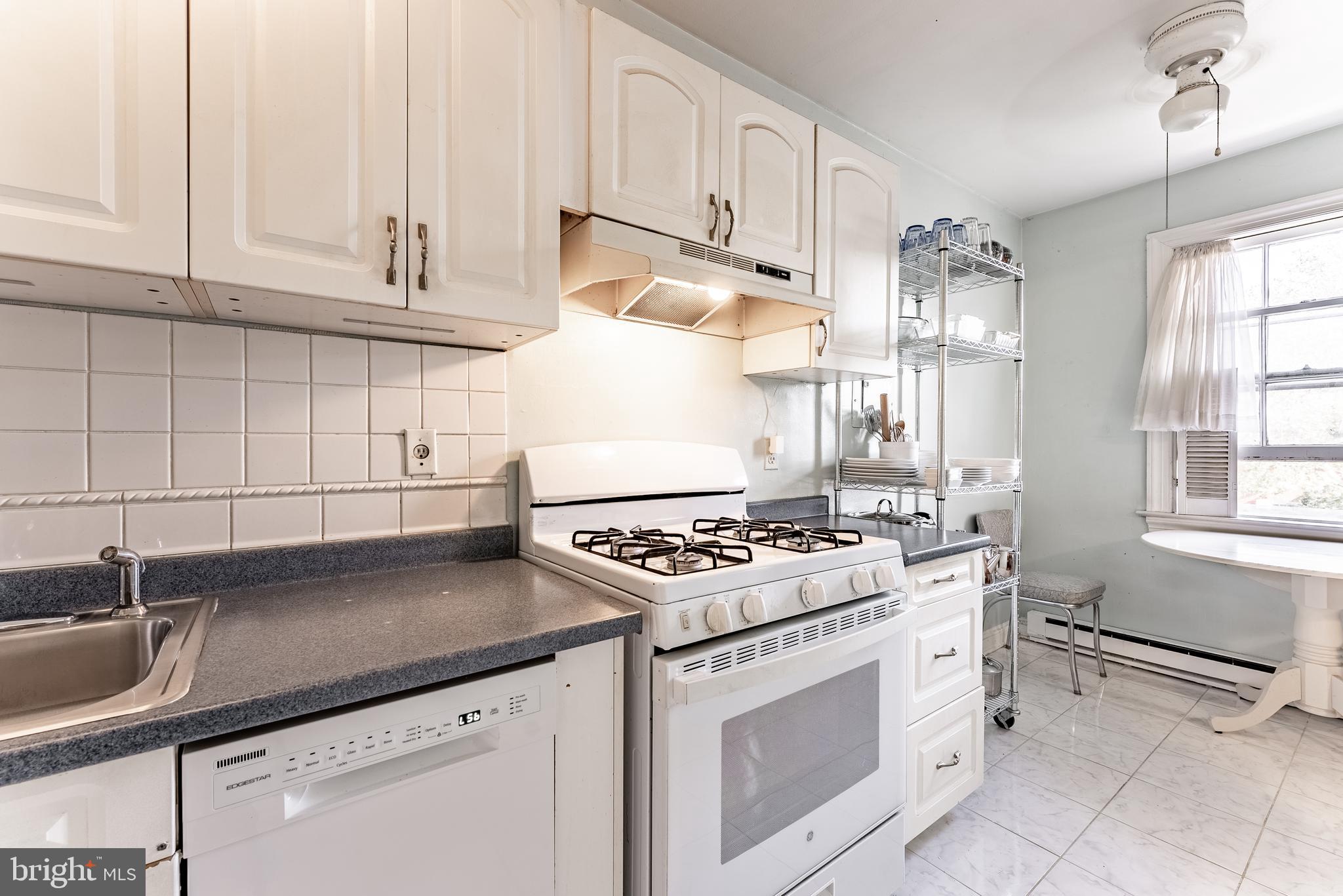 715 South Washington Street, Unit A16 Alexandria, VA 22314 - Photo 21 of 23 a kitchen with granite countertop a stove sink and cabinets