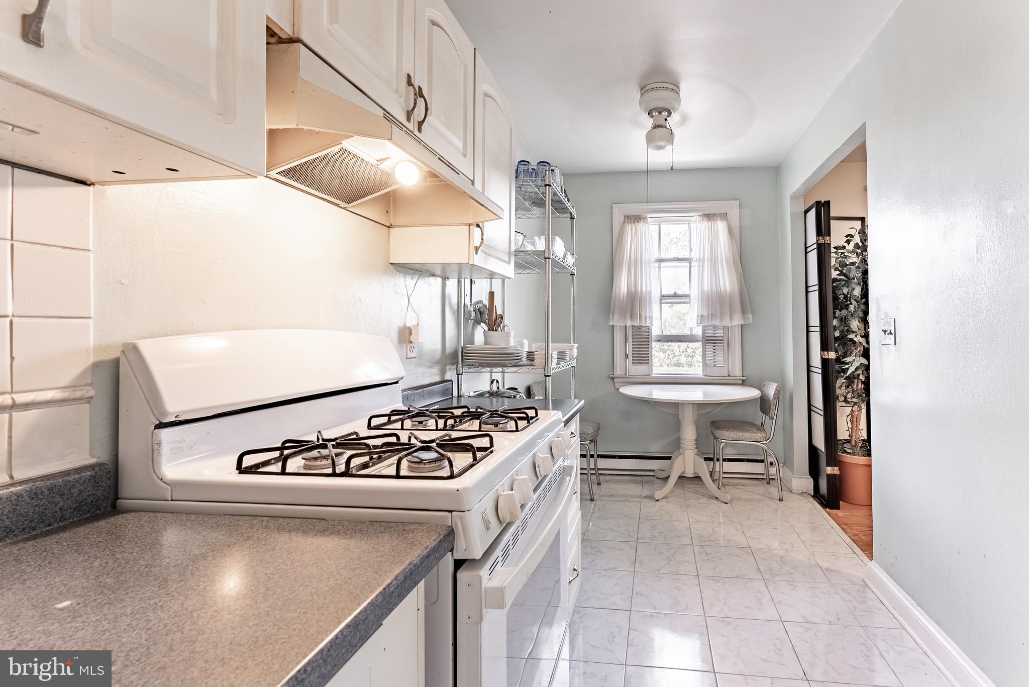 715 South Washington Street, Unit A16 Alexandria, VA 22314 - Photo 5 of 23 a kitchen that has a stove and a table in it