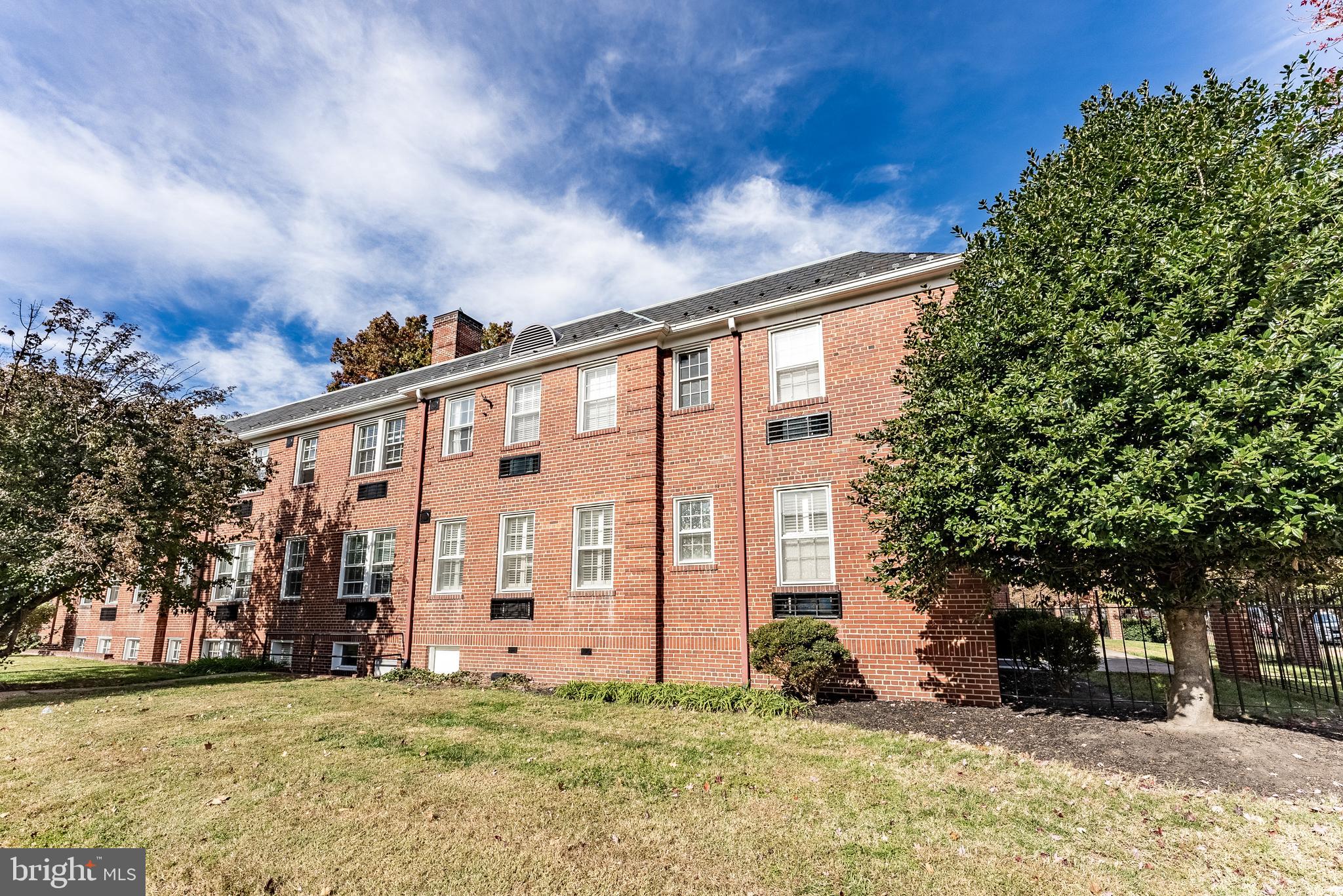 715 South Washington Street, Unit A16 Alexandria, VA 22314 - Photo 8 of 23 a view of a house with a big yard and large trees