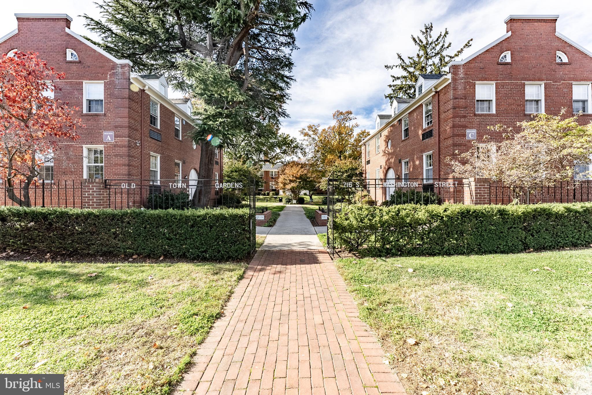 715 South Washington Street, Unit A16 Alexandria, VA 22314 - Photo 10 of 23 a view of a brick house next to a yard with big trees