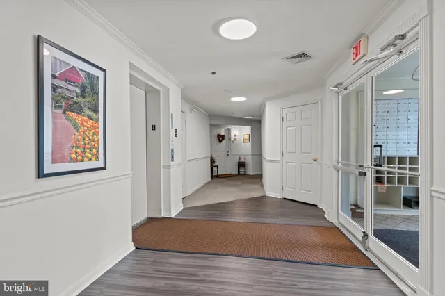 a view of a hallway with wooden floor and entryway