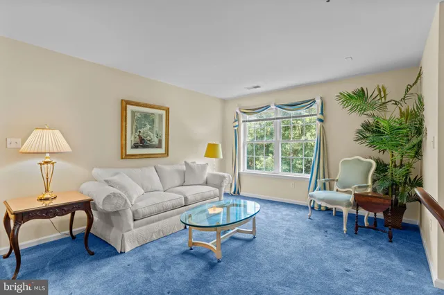 a living room with furniture a table and a large window