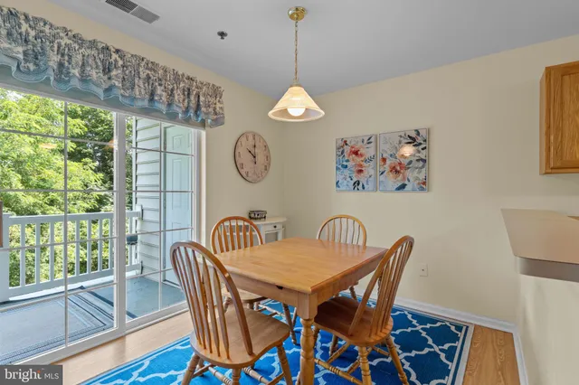 a view of a dining room with furniture a chandelier and wooden floor