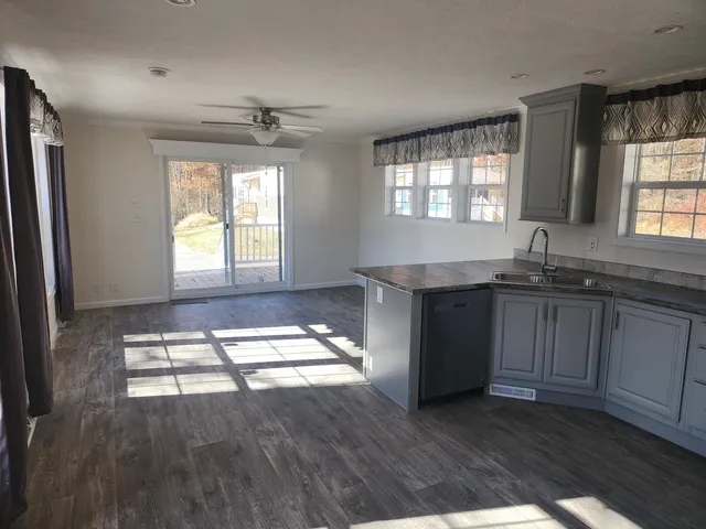 a kitchen with granite countertop a stove a sink and wooden floor