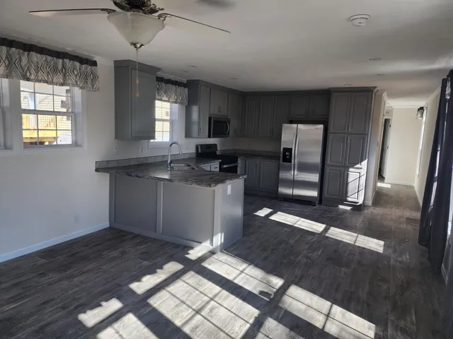 a kitchen with stainless steel appliances granite countertop a sink stove a refrigerator and cabinets