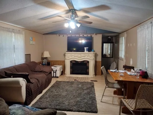 a living room with furniture a fireplace and a flat screen tv