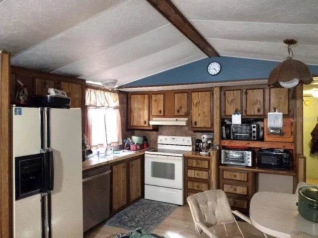 a kitchen with stainless steel appliances a stove a refrigerator and a dining table