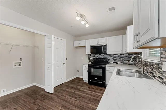 a kitchen with stainless steel appliances a stove sink microwave and cabinets