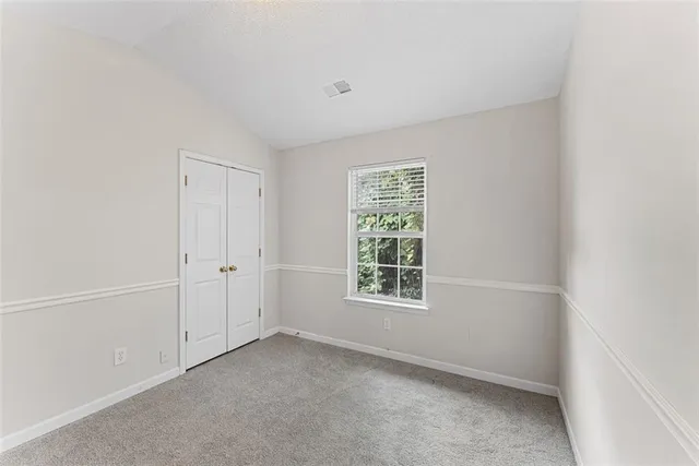 an empty room with windows and closet