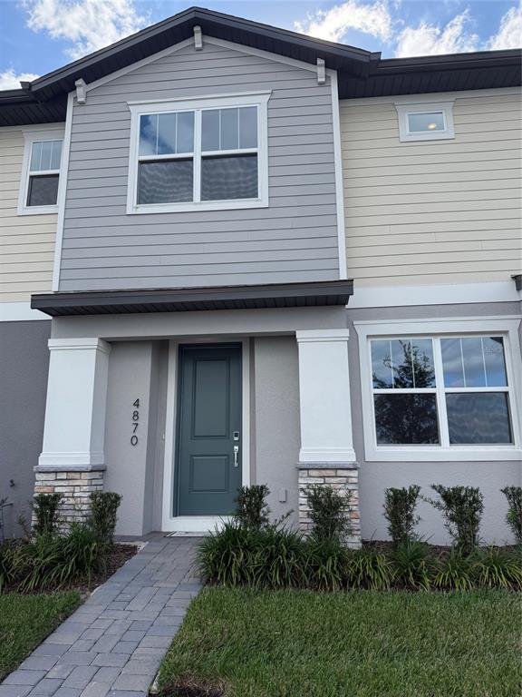a front view of a house with a yard and outdoor seating