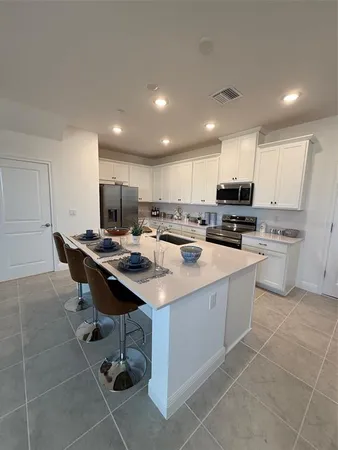 a kitchen with a sink a counter top space appliances and cabinets