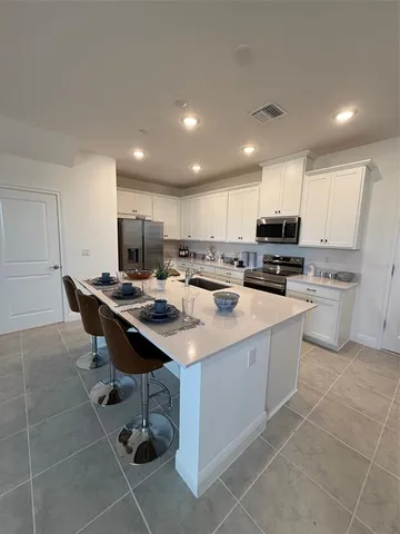 a kitchen with a sink a counter top space appliances and cabinets