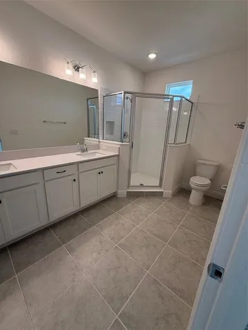 a bathroom with a double vanity sink and a toilet