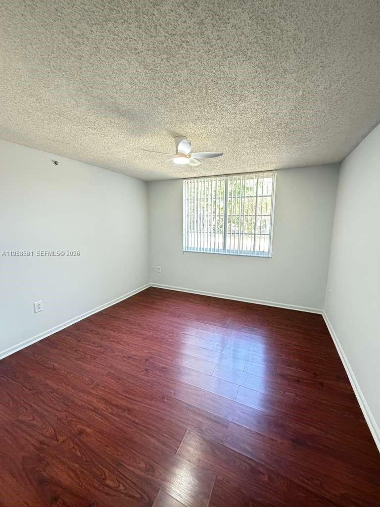 2173 Renaissance Boulevard, Unit 101 Miramar, FL 33025 - Photo 13 of 27 an empty room with wooden floor and windows