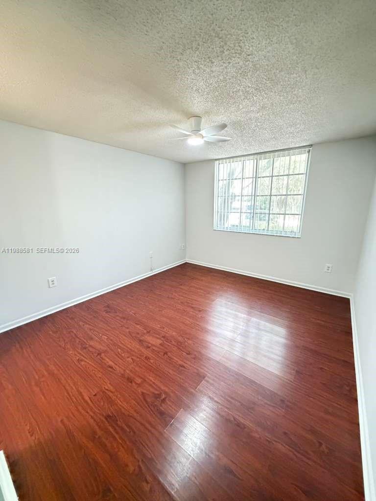 2173 Renaissance Boulevard, Unit 101 Miramar, FL 33025 - Photo 14 of 27 an empty room with wooden floor and windows