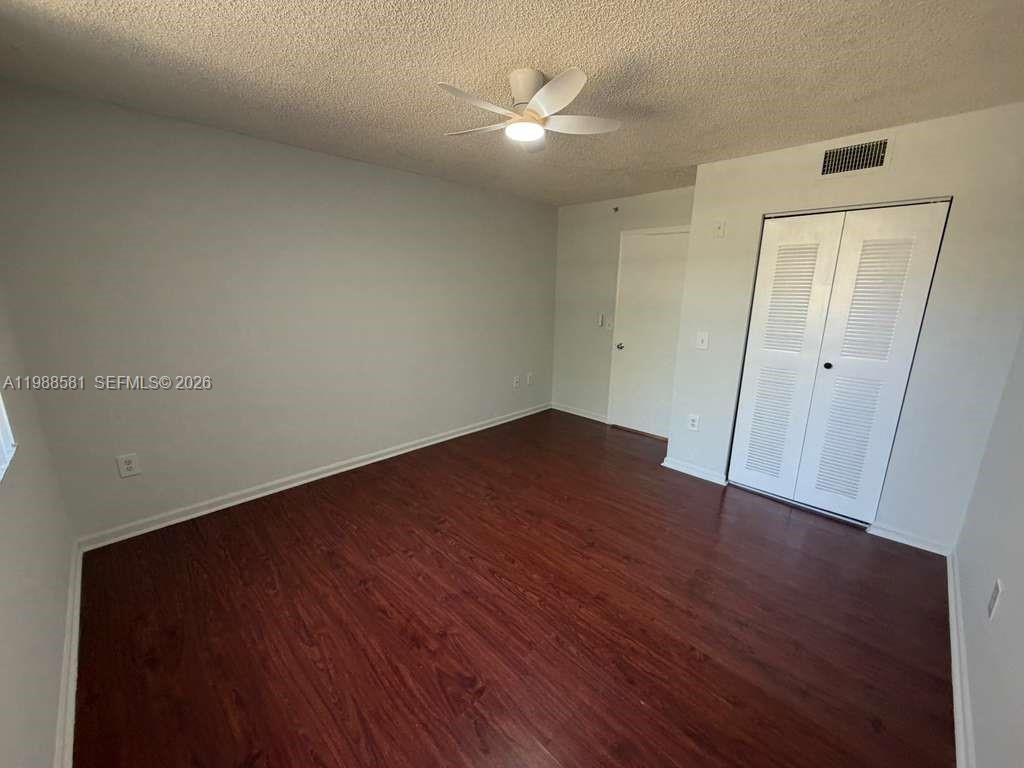 2173 Renaissance Boulevard, Unit 101 Miramar, FL 33025 - Photo 18 of 27 an empty room with wooden floor and a ceiling fan