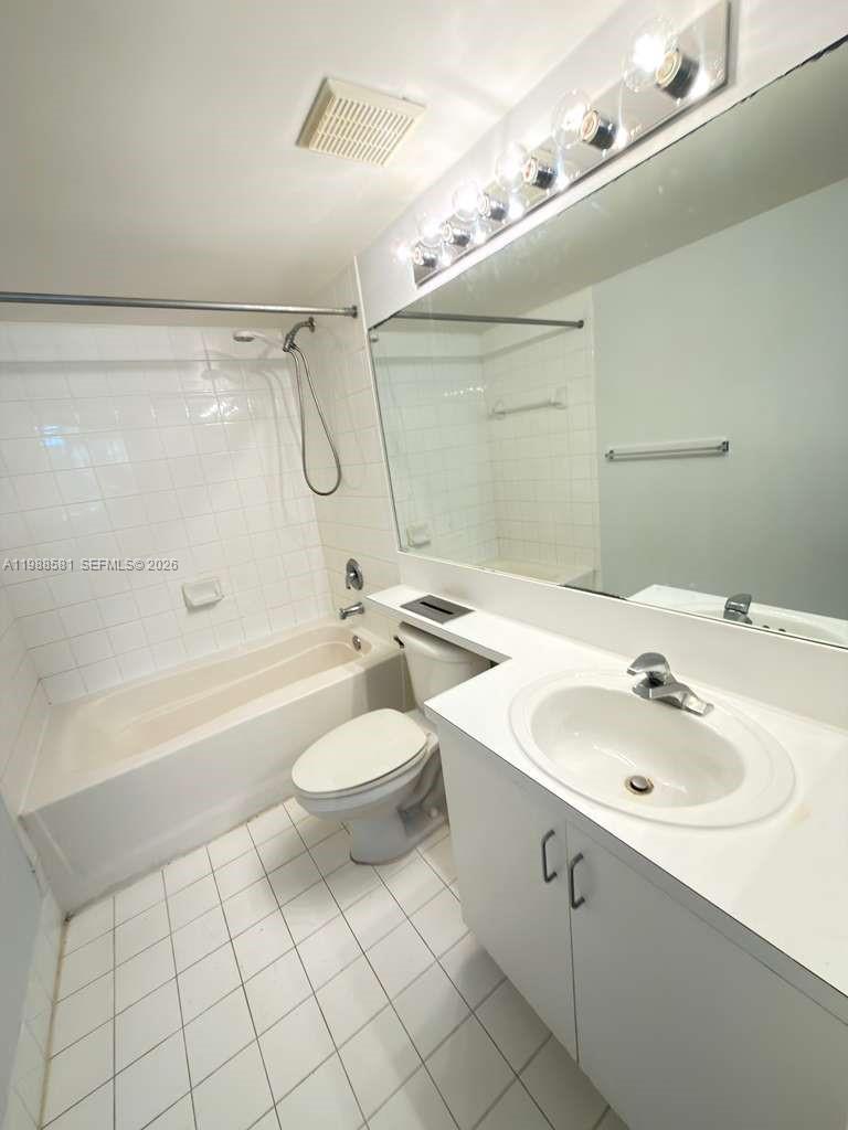 2173 Renaissance Boulevard, Unit 101 Miramar, FL 33025 - Photo 20 of 27 a bathroom with a toilet a sink a mirror and bathtub