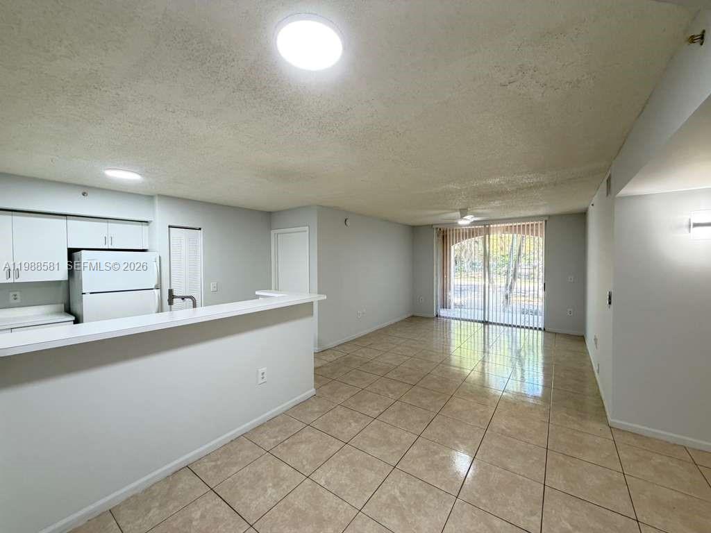 2173 Renaissance Boulevard, Unit 101 Miramar, FL 33025 - Photo 7 of 27 a large white kitchen with a sink and cabinets