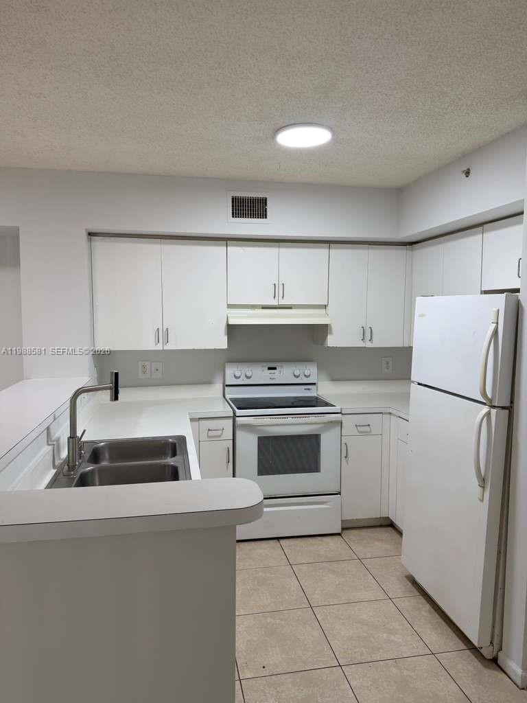 2173 Renaissance Boulevard, Unit 101 Miramar, FL 33025 - Photo 10 of 27 a kitchen with a stove sink and refrigerator