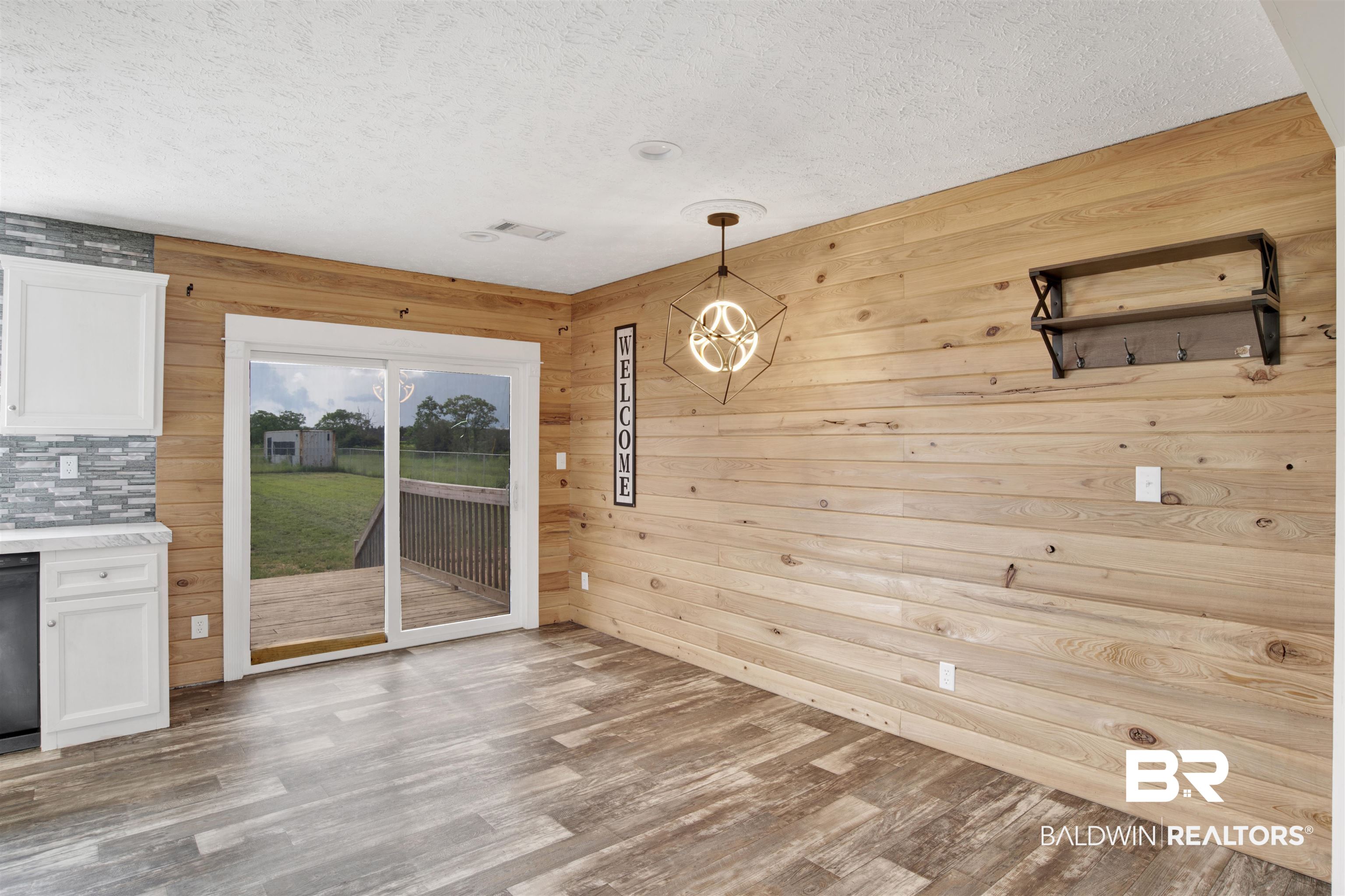 16778 County Road 87 Elberta, AL 36530 - Photo 13 of 32 Unfurnished dining area featuring light hardwood / wood-style floors, wood walls, a notable chandelier, and a textured ceiling