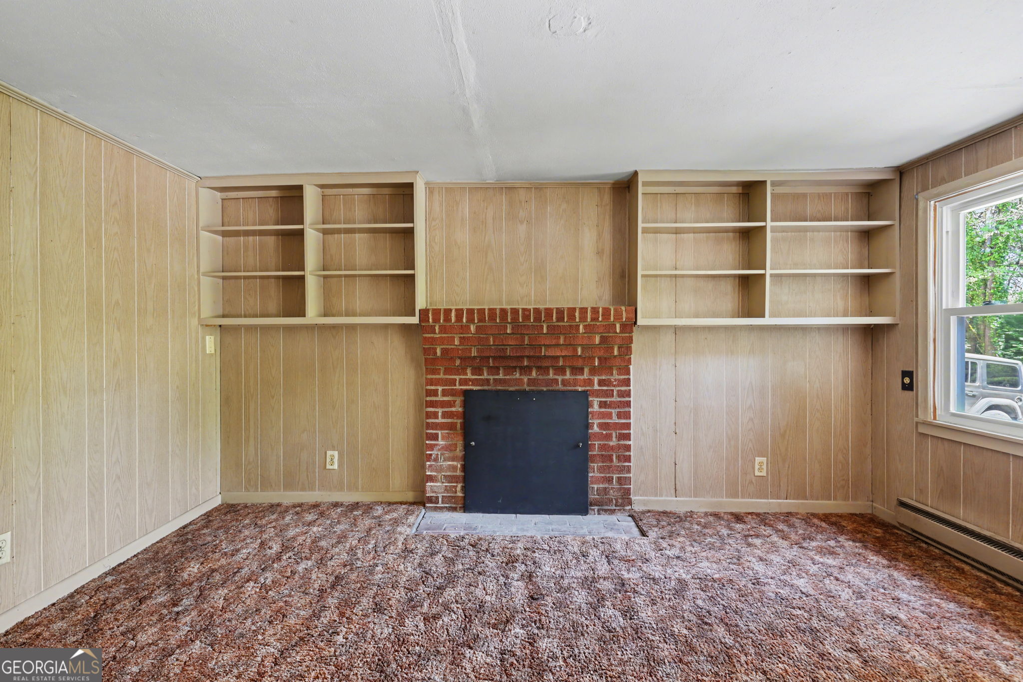 138 Taylors Chapel Road Rabun Gap, GA 30568 - Photo 14 of 52 a view of an empty room with a fireplace and a window