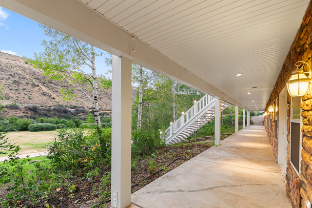 1133 Paris Canyon Road Paris, ID 83261 - Photo 48 of 74 Stone facade walkway with overhead lighting and a white staircase leading to an upper level