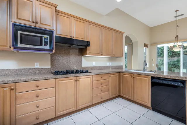 a kitchen with granite countertop white cabinets stainless steel appliances and a sink