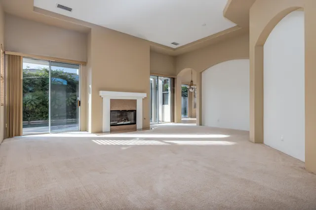 a view of an empty room with a fireplace and a window