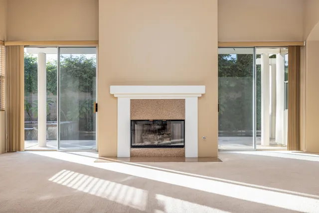 a living room with a fireplace and a glass door