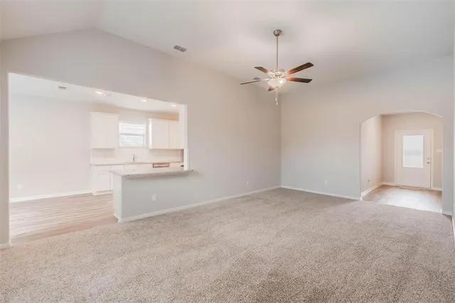 an empty room with a bathroom and a ceiling fan