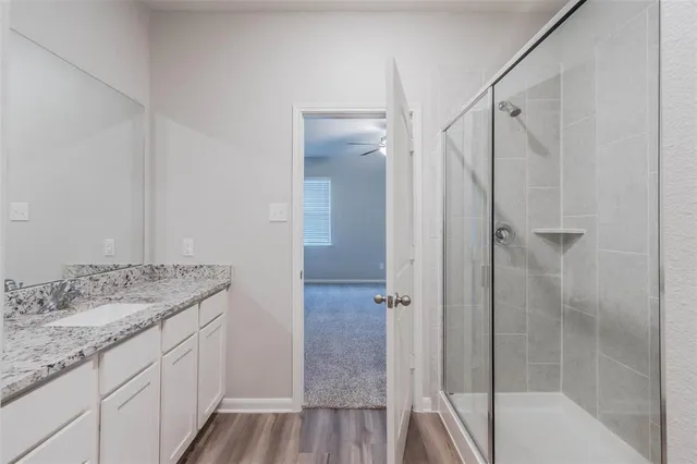 a bathroom with a granite countertop sink toilet and shower