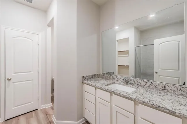 a bathroom with a granite countertop sink and a mirror
