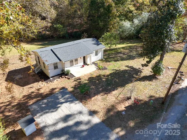 a white house sitting in middle of forest