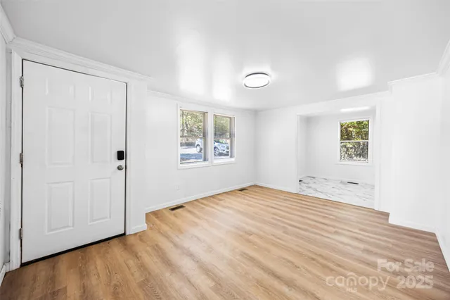 a view of an empty room with window and closet area
