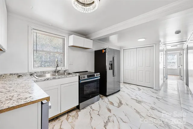 a kitchen with granite countertop a stove a refrigerator and a sink