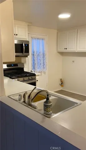 a kitchen with a sink a stove and cabinets
