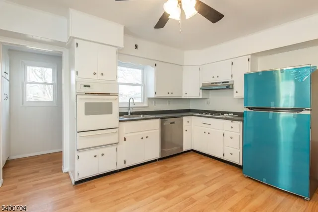 a kitchen with granite countertop white cabinets and white appliances