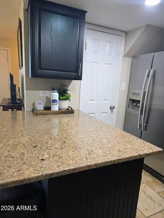 a kitchen with granite countertop a sink a stove and refrigerator