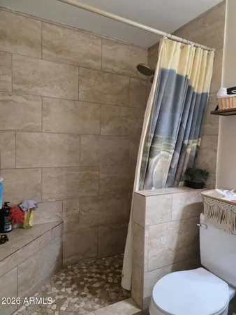 a bathroom with a toilet and a shower