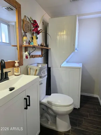 a bathroom with a sink mirror vanity and toilet