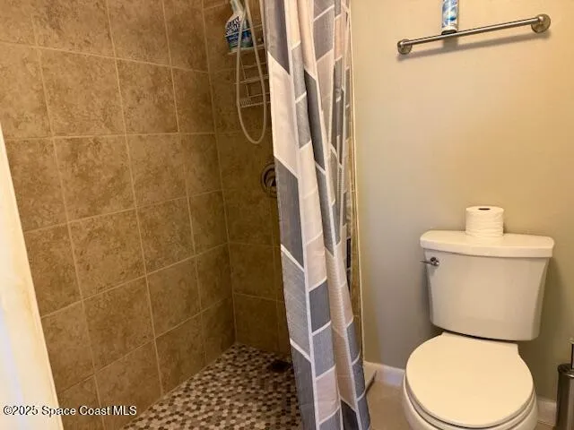 a white toilet sitting next to a shower and a sink