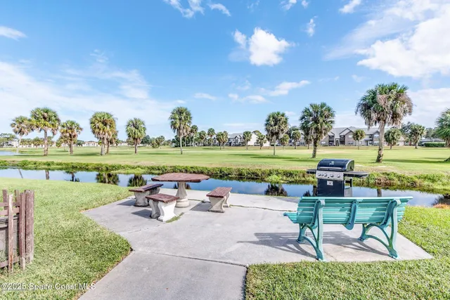 a swimming pool with outdoor seating and a garden