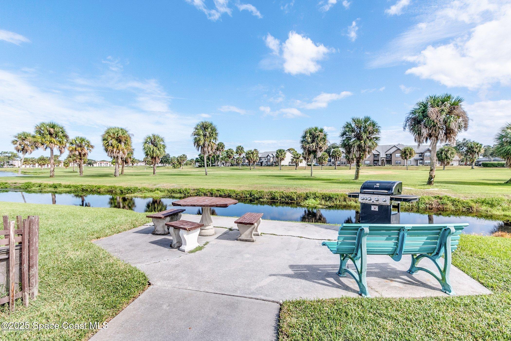 2727 North Wickham Road, Unit 20510 Melbourne, FL 32935 - Photo 22 of 25 a swimming pool with outdoor seating and a garden