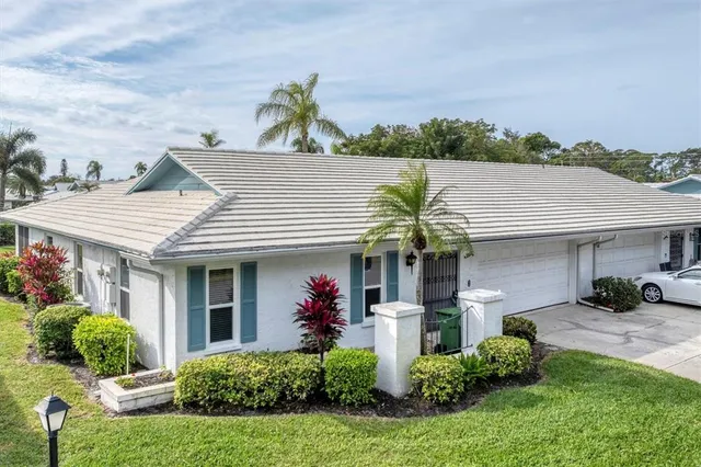 a front view of a house with a garden and plants