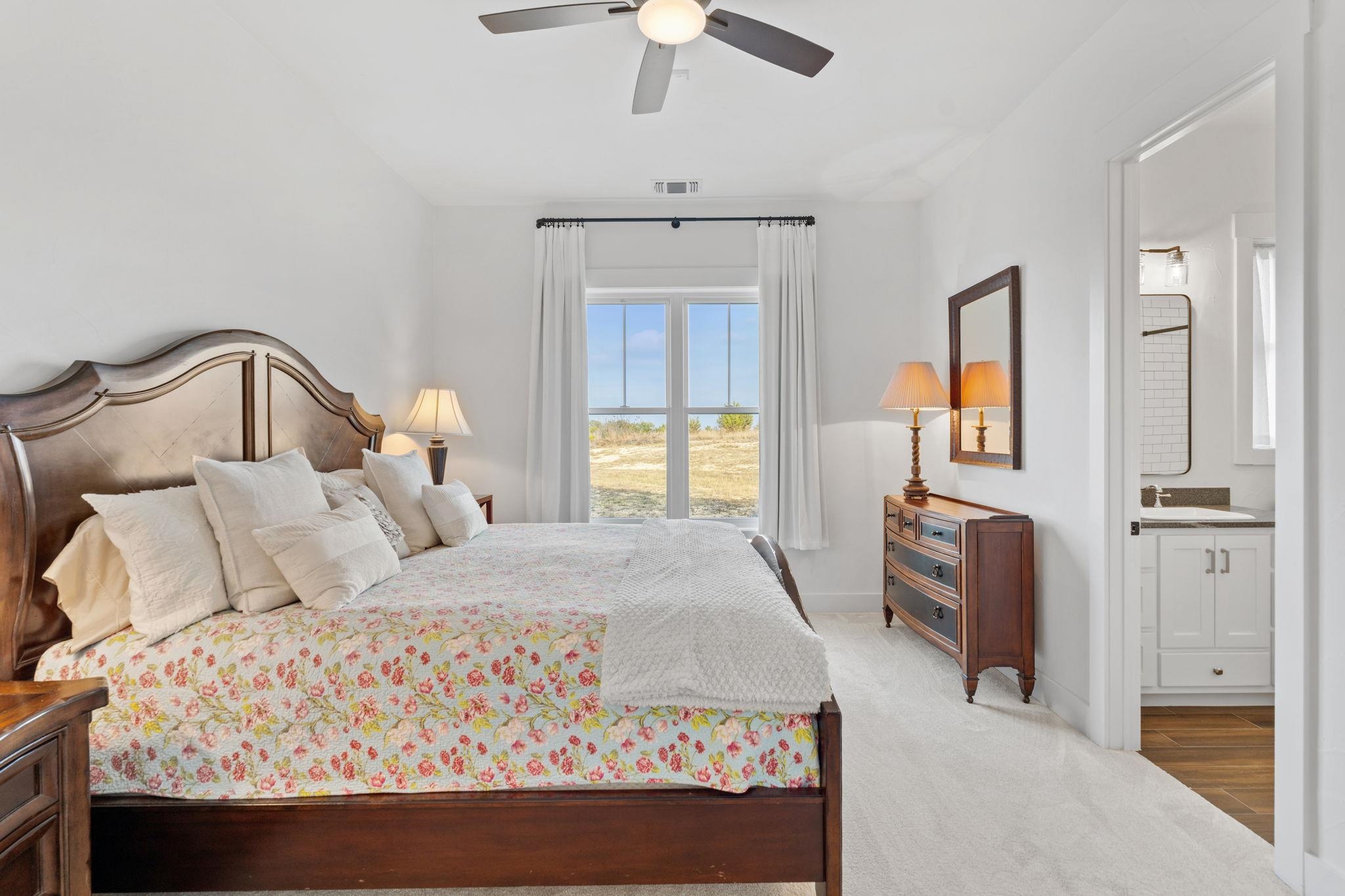 452 Southwick Ranch Road Johnson City, TX 78636 - Photo 16 of 44 a bedroom with a bed and a chandelier