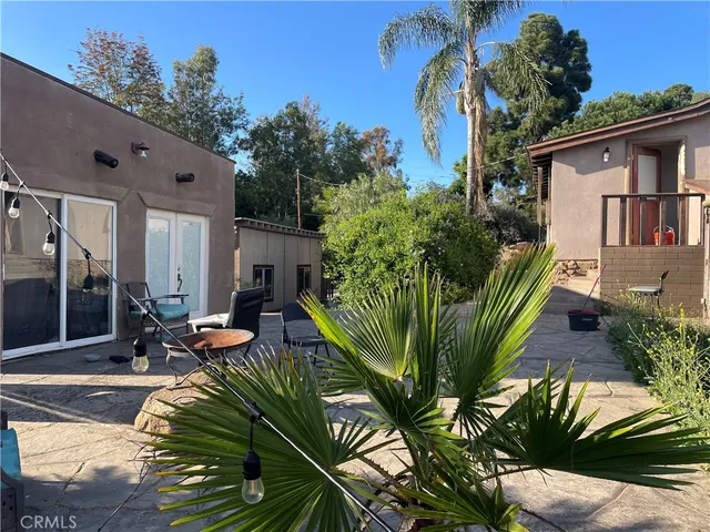 a view of a house with backyard and sitting area