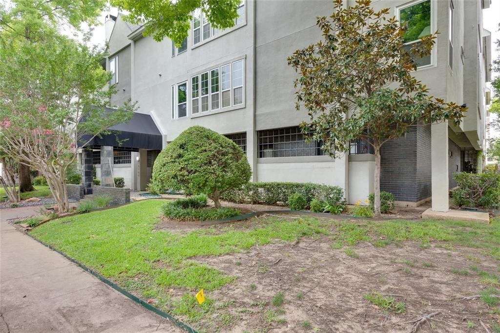 4104 North Hall Street, Unit 102 Dallas, TX 75219 - Photo 4 of 18 Multi-story building featuring a neutral-toned exterior, prominent bay windows, and a black fabric awning over the entrance