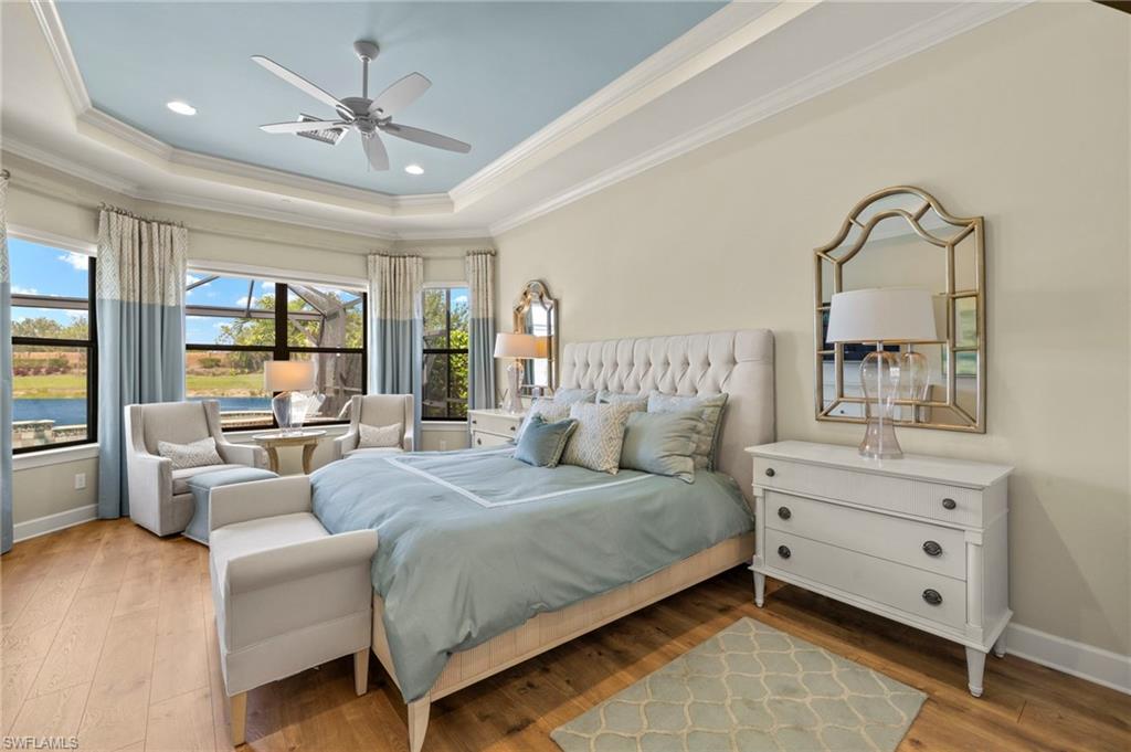 10234 Coconut Road Estero, FL 34135 - Photo 16 of 36 a bedroom with a large bed and a chandelier